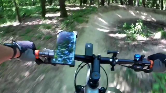 Riding a mountain bike down a forest trail, seen from the handlebars