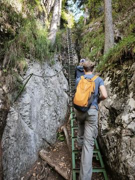 Climbing steel ladders up a narrow rocky gorge